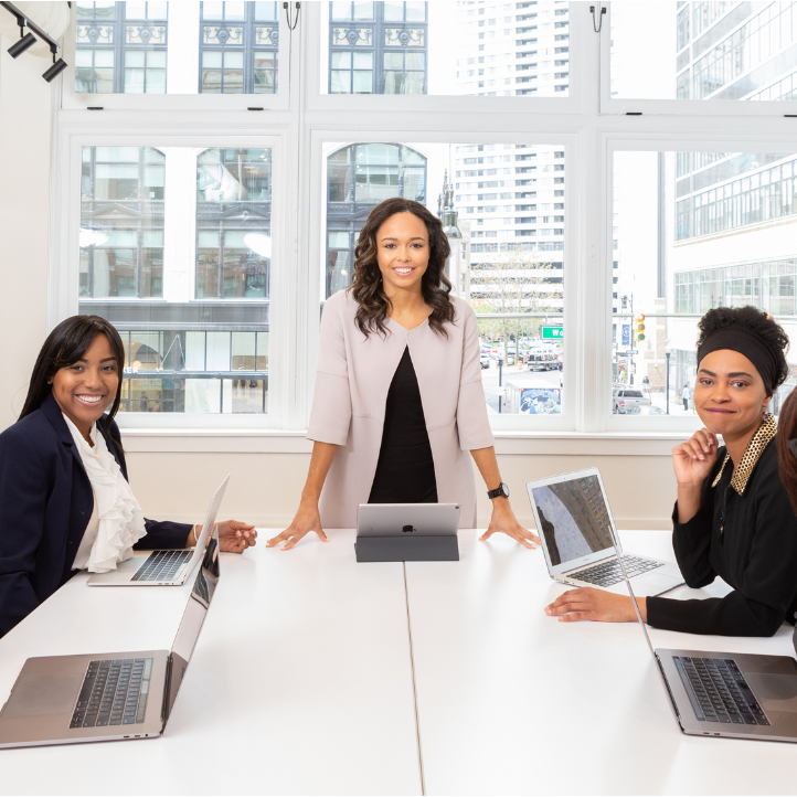 Group of professionals in a meeting room with laptops and tablets.