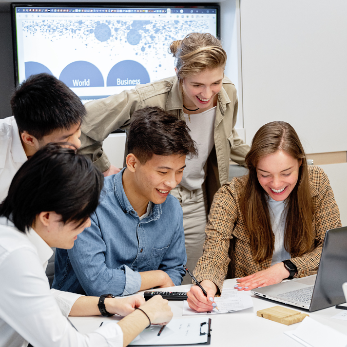 Two professionals standing, one holding a paper and another pointing at it.